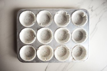 Line a 12-hole muffin tray with paper liners.