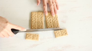 Slicing bottom fourth off two crackers