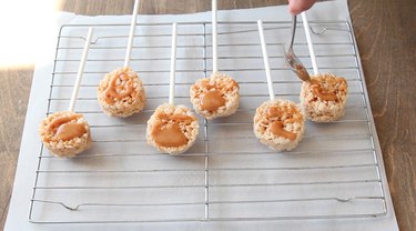Drizzling caramel sauce on Krispies pops.