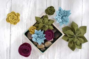DIY felt succulent plants placed on top of river rocks in a container