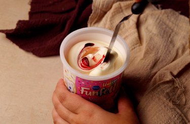 Dying vanilla frosting with red food coloring to make it pink.