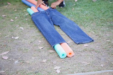 slipping pool noodles through the jeans legs