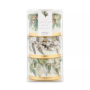 Set of three 3-oz. tin candles with festive greenery on the packaging.