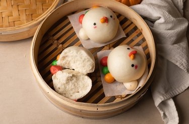 Fluffy steamed buns in a steamer basket.