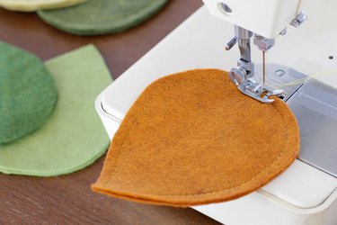 sewing along the perimeter of the felt leaf cutout with a sewing machine