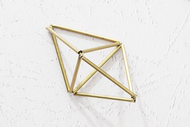 Wires twisted through metal tubes to create two triangles, then connected to create a 3-D diamond shape