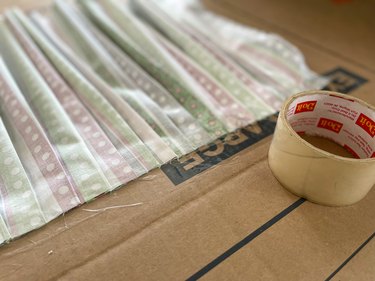 Put packing tape on top of hot-glued curtain to assure the curtain stays put