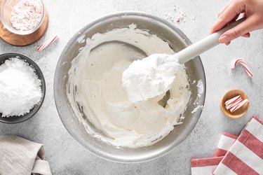Whipped topping on a white spatula over a bowl