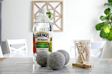 Bottle of vinegar with felt dryer balls