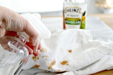 Spraying vinegar on clothing stains