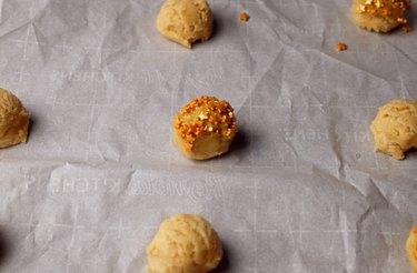 Sugar cookies with star sprinkles on a lined baking sheet, ready for the oven
