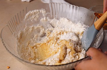Using a rubber spatula to stir in dry ingredients