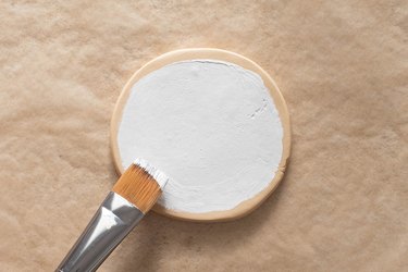 Add white paint to clay coaster