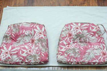 Patio cushions lined up along the folded drop cloth