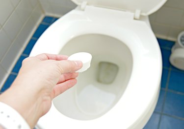 Adding 3 ingredient toilet cleaning bombs to a toilet