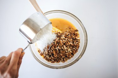 Adding in the pecans and coconut to the cooked caramel mixture.