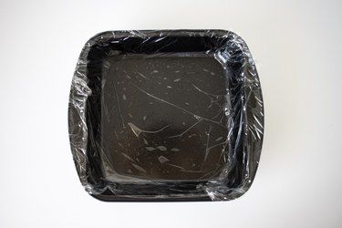 Baking tin lined with plastic wrap.