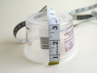 A tailors tape measuring the height of the tub.