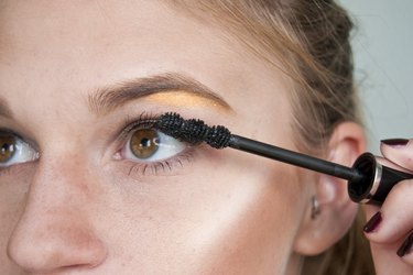 a woman applying mascara