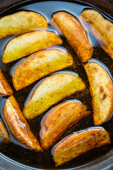 Potato wedges pan-frying in oil
