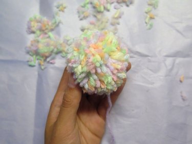 Hand holding a yarn pompom