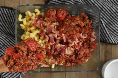Bacon, pasta and beef added to a casserole dish