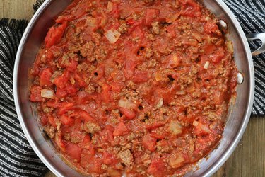 Diced tomatoes added to a pan for Cheeseburger Casserole Recipe
