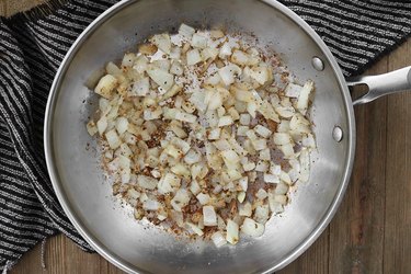Onions and garlic cooking in a pan for a Cheeseburger Casserole Recipe