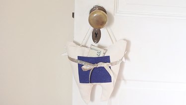 Back side of tooth fairy pillow with money in pouch
