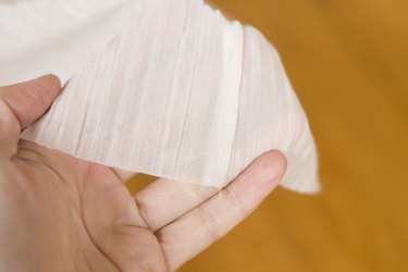 ...Woman's hand holding chiffon, displaying its weave