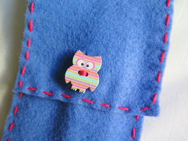 The button pulled through the slit of the DIY felt pencil case