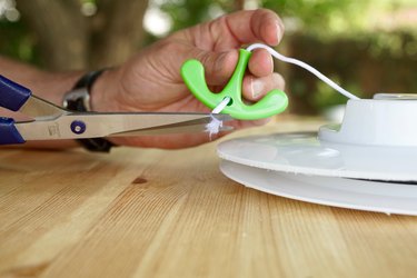 Scissors are shown cutting a cord