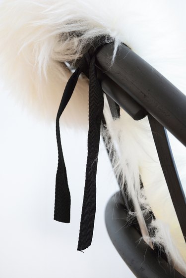 Tie sheep skin onto the back of the chair.
