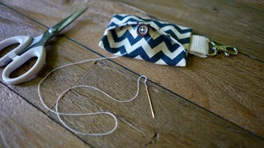 Sewing button onto DIY dog waste bag dispenser