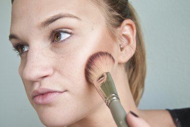 a woman contouring her cheekbones