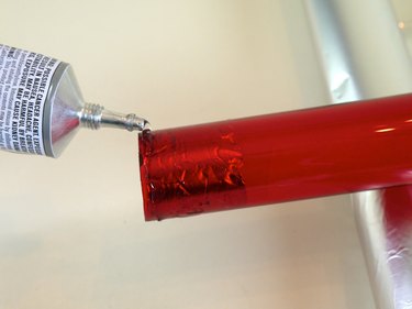 A bead of epoxy around the end of a red tube.
