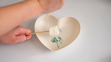 drizzling white chocolate over marshmallow pops