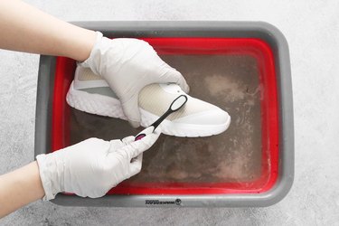 Scrubbing white mesh sneakers with sodium percarbonate