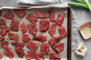 Strips of beef on a baking sheet