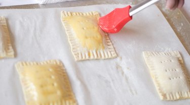 Egg-washing tarts before baking