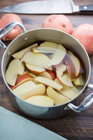 Potato wedges soaking in a large bowl of water
