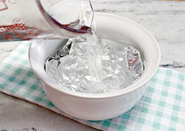 Pouring water over foil in bowl
