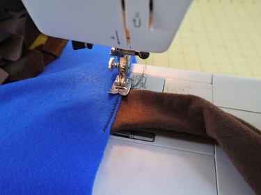 A sewing machine attaching the tail to the vest.
