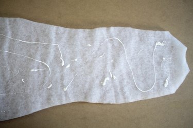 Place felt glue onto one side of the batting.