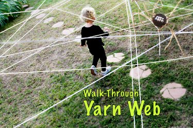 child walking through a web of yarn outside