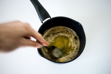 Hand stirring butter and vanilla mixture in a hot saucepan.