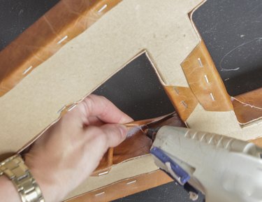 On the inside of the letter "A," gluing the loose fabric in place.