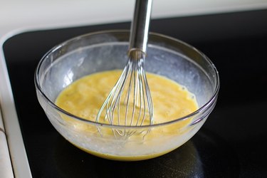 Bowl with beaten eggs and a whisk