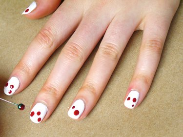 Two or three dots of red polish on each nail.