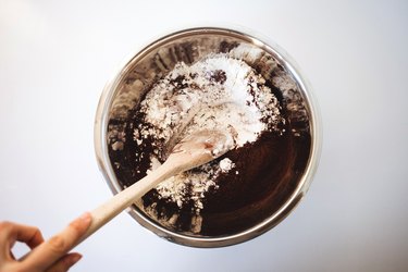 Mixing the dry ingredients in a bowl with a wooden spoon.